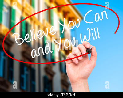Man Hand writing Believe You Can and You Will with black marker on visual screen Stock Photo