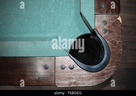 Very old part of green with wooden edges and black ball hole pool table background Stock Photo