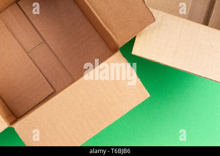 Empty open cardboard boxes on green background Stock Photo