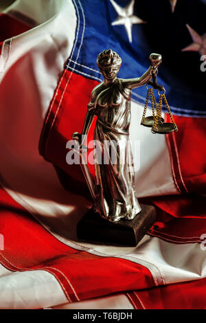 Law and Justice in United States of America, statue of Lady Justice with USA flag in background, selective focus Stock Photo