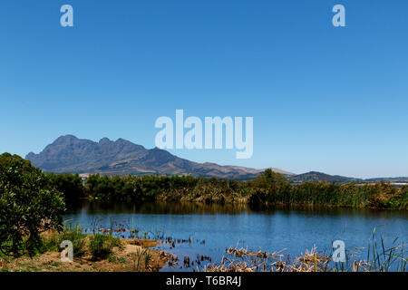 Dam, Bushes and Mountain View Stock Photo