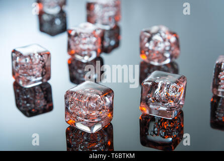 Glowing ice cubes on reflective surface Stock Photo