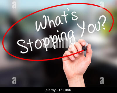 Man Hand writing What's Stopping You?  with black marker on visual screen Stock Photo