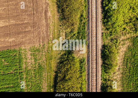 Aerial view of railway through countryside landscape, top down perspective from drone pov Stock Photo