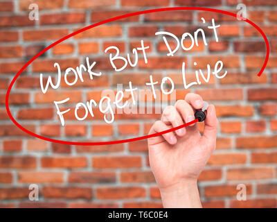 Man Hand writing Work But Don't Forget to Live  with black marker on visual screen Stock Photo