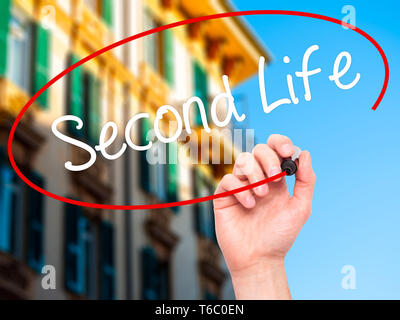 Man Hand writing Second Life with black marker on visual screen. Stock Photo