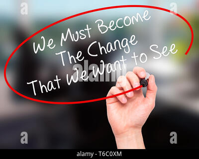 Man Hand writing We Must Become The Change That We Want to See with black marker on visual screen Stock Photo