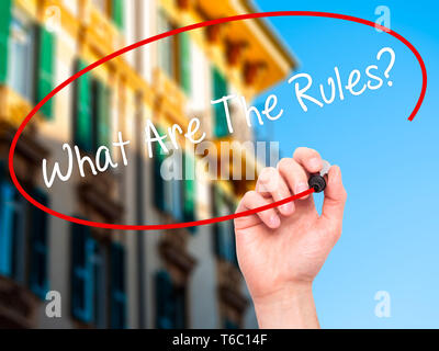 Man Hand writing What Are The Rules?  with black marker on visual screen Stock Photo