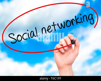 Man Hand writing Social networking with black marker on visual screen Stock Photo