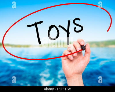 Man Hand writing Toys  with black marker on visual screen Stock Photo