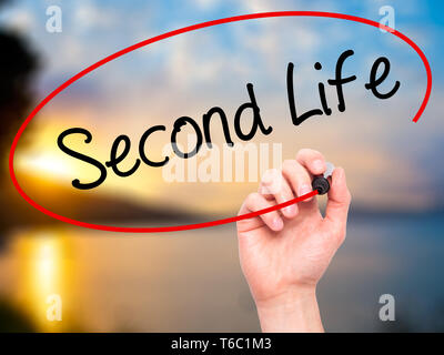 Man Hand writing Second Life with black marker on visual screen. Stock Photo