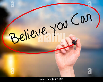 Man Hand writing Believe you Can with black marker on visual screen Stock Photo