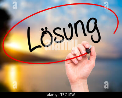 Man Hand writing Losung (Solution in German) with black marker on visual screen. Stock Photo