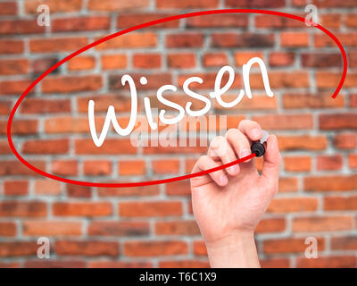 Man Hand writing Wissen (Know in German)  with black marker on visual screen Stock Photo