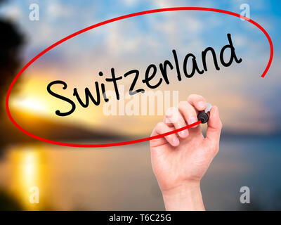 Man Hand writing Switzerland  with black marker on visual screen Stock Photo