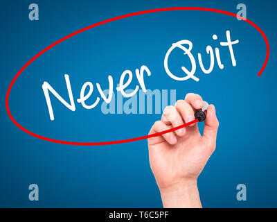 Man Hand writing Never Quit with black marker on visual screen. Stock Photo