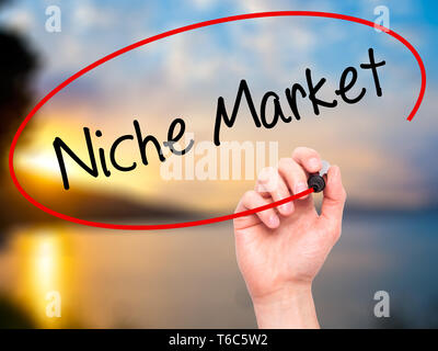 Man Hand writing Niche Market with black marker on visual screen. Stock Photo