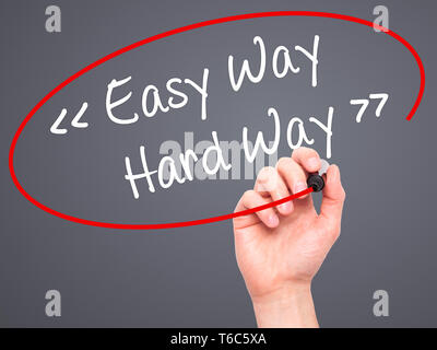 Man Hand writing Easy Way - Hard Way with black marker on visual screen. Stock Photo
