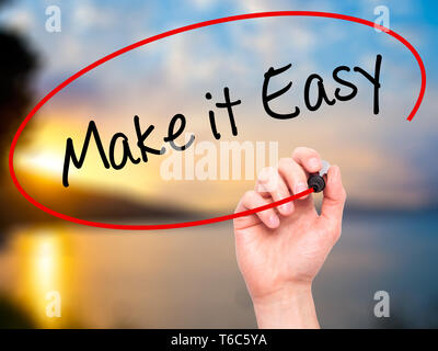 Man Hand writing Make it Easy with black marker on visual screen Stock Photo