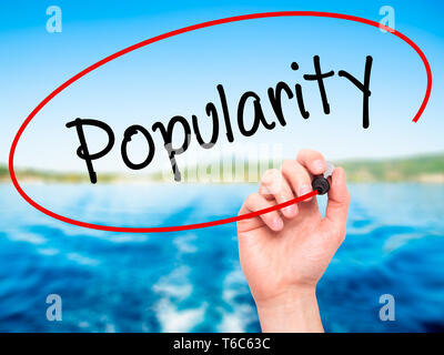 Man Hand writing Popularity with black marker on visual screen. Stock Photo