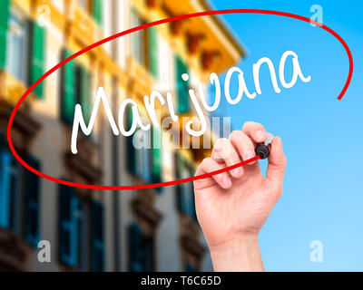 Man Hand writing Marijuana with black marker on visual screen Stock Photo
