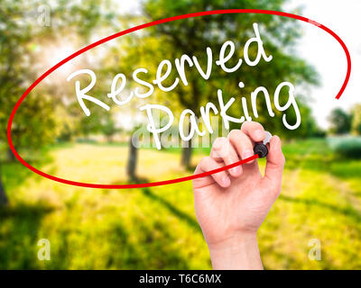 Man Hand writing Reserved Parking with black marker on visual screen Stock Photo