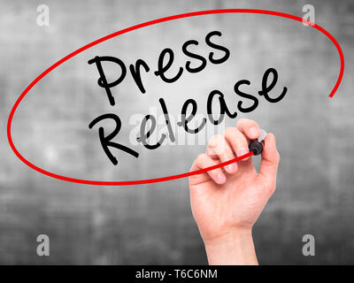 Man Hand writing Press Release with marker on transparent wipe board Stock Photo
