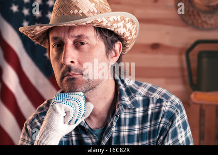 Portrait of confident american male farmer with USA flag in the background looking at camera Stock Photo