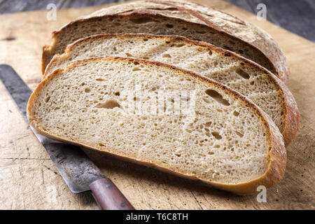 Freshly backed Farmhouse Bread sliced as close-up on an old cutting board Stock Photo