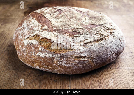 Freshly backed Farmhouse Bread as close-up on an old wooden board Stock Photo