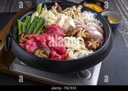 Traditional Sukiyaki pot with Kobe Beef and Vegetable as close-up on slate Stock Photo