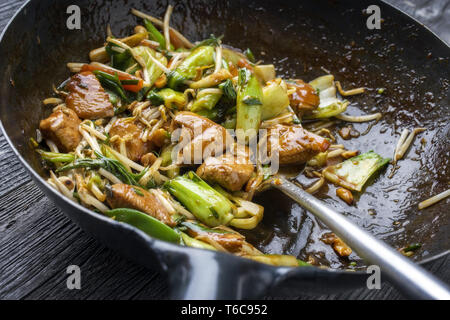 Traditional stir fried Chicken Gung Bao with Vegetable as close-up in Wok Stock Photo