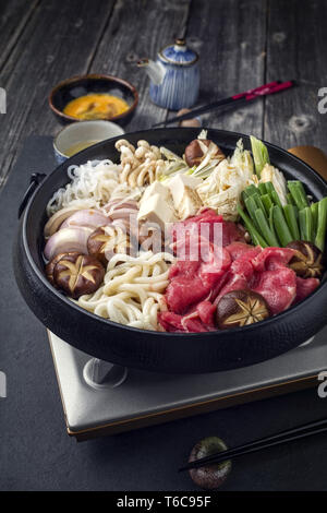 Traditional Sukiyaki pot with Kobe Beef and Vegetable as close-up on slate Stock Photo