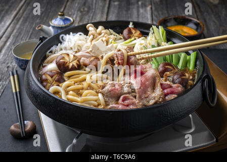 Traditional Sukiyaki pot with Kobe Beef and Vegetable as close-up on slate Stock Photo