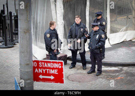 Four NYPD policemen guarding the entrance to the NYSE Euronext Stock Exchange on Wall Street Stock Photo