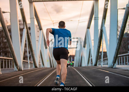 Male athlete running, exercising indoors, jogging rear view, full length. Self overcome concept. Workout concept .Healthy lifestyle. Stock Photo