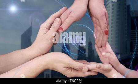 Men's, women's and children's hands show a hologram VR Stock Photo