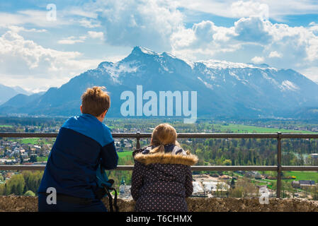 Children travel, rear view of children looking at an alpine mountain range from a viewing terrace in Salzburg Castle (Hohensalzburg), Austria. Stock Photo