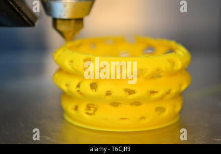 3d printer printing objects yellow form closeup. Modern technical 3D printing. Stock Photo