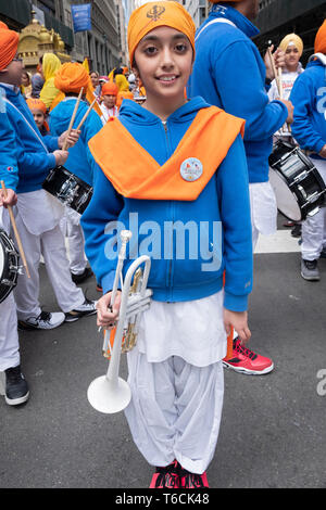 A teenage trumpeter with a white horn poses for a photo prior to the start of the Sikh Day Parade in Manhattan, New York City. Stock Photo