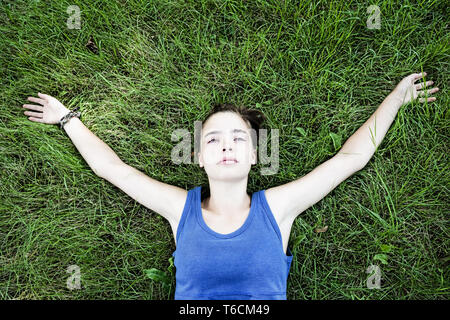 portrait of a young woman lying on a meadow Stock Photo