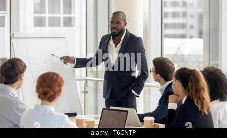 African american coach talking to audience giving presentation on flipchart Stock Photo