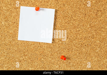Cork board with pinned blank notepaper. Stock Photo