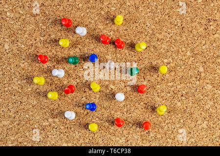 Group of colorful push pins on cork bulletin board. Stock Photo