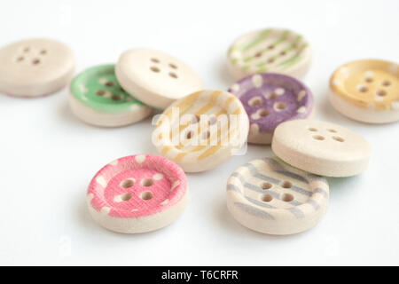 Wooden buttons with colorful stripes and colorful dots on a white background. Sewing Stock Photo