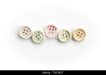 Wooden buttons with colorful stripes and colorful dots on a white background. Sewing Stock Photo