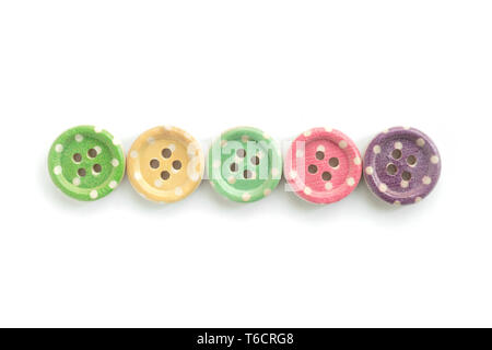 Wooden buttons with colorful stripes and colorful dots on a white background. Sewing Stock Photo