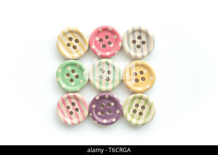 Wooden buttons with colorful stripes and colorful dots on a white background. Sewing Stock Photo