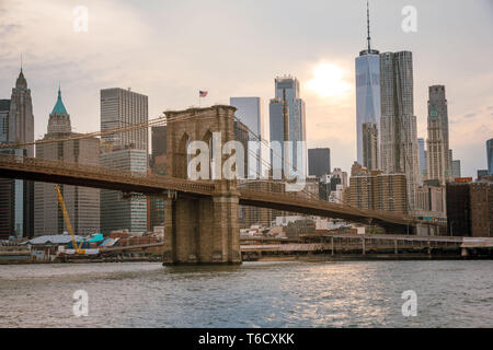 Sonnenuntergang und Boote auf dem East River unter der Brücke am 04.07.2018 zum Unabhängigkeitstag / sunset ship on east river under bridge Stock Photo