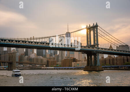 Sonnenuntergang und Boote auf dem East River unter der Brücke am 04.07.2018 zum Unabhängigkeitstag / sunset ship on east river under bridge Stock Photo